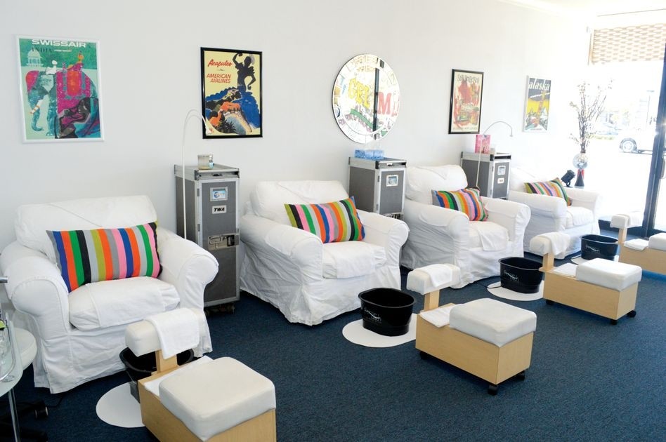 Vintage airline posters grace the walls behind comfortable pedicure chairs
