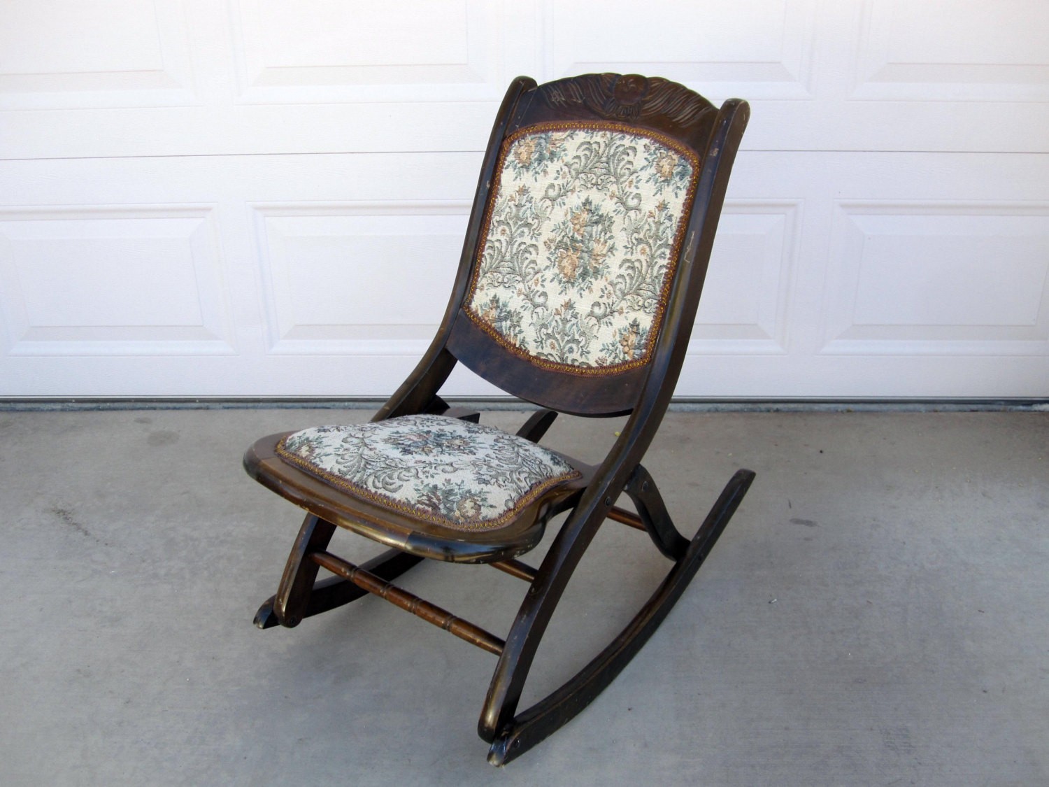 Antique mahogany folding rocking chair with floral patterned seat and