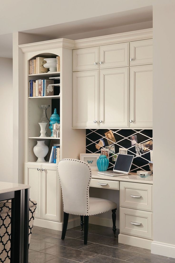 A built in desk with bookcase and cabinets creates a
