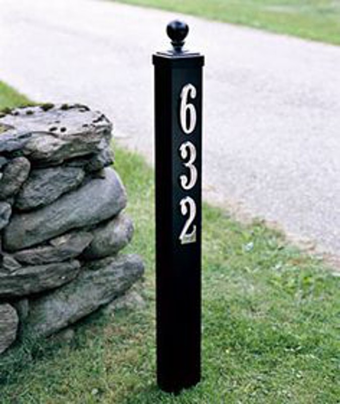 House numbers are mounted on a wooden deck or fence