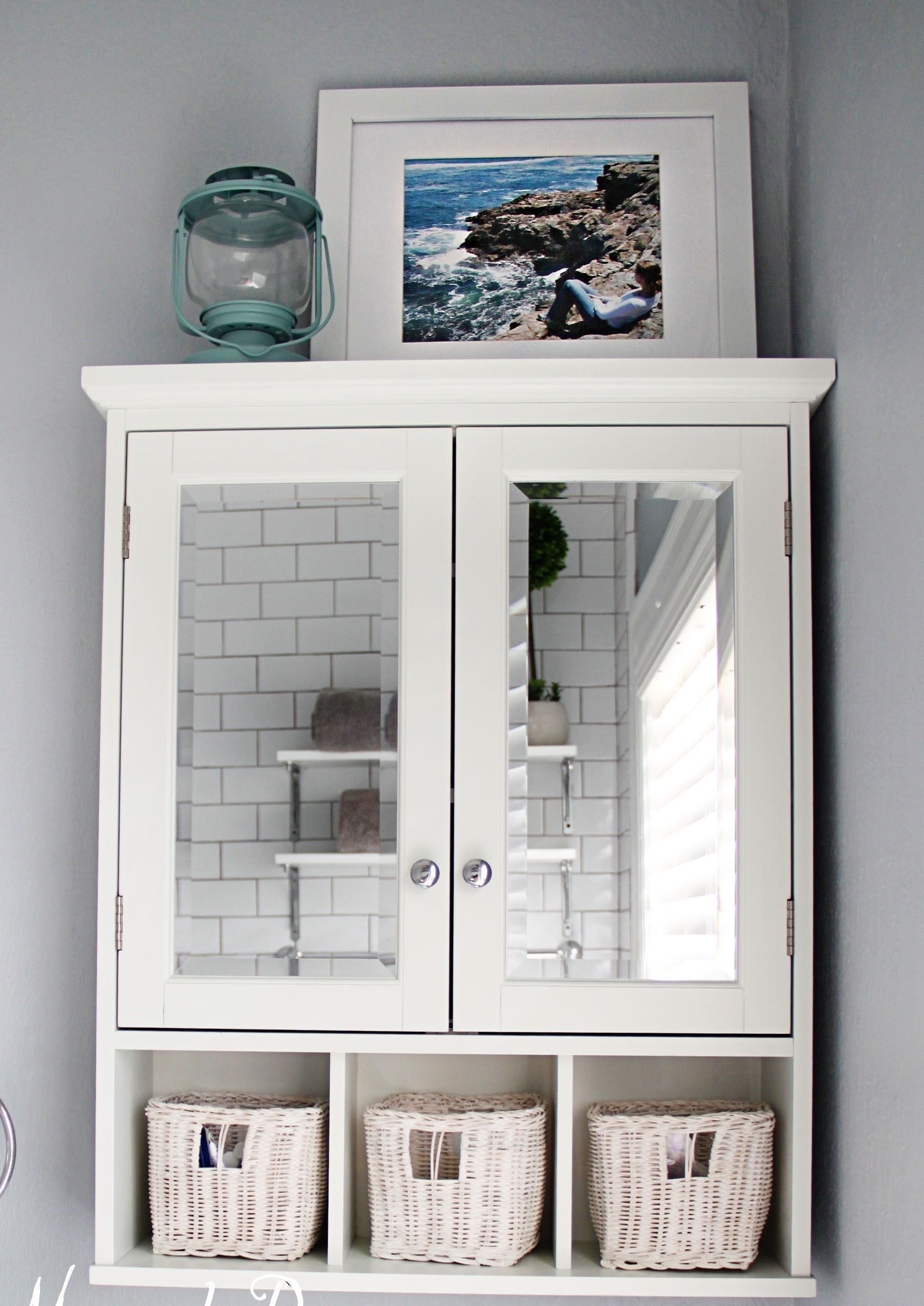 Mirror over the toilet cabinet and racks as storage in
