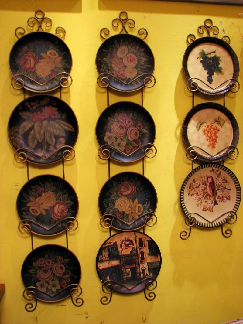 Decorative plates hang on wall decor and black wrought iron