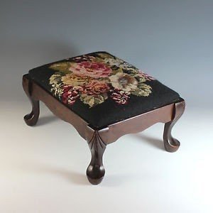 About antique carved foot stool with black needlepoint top footstool