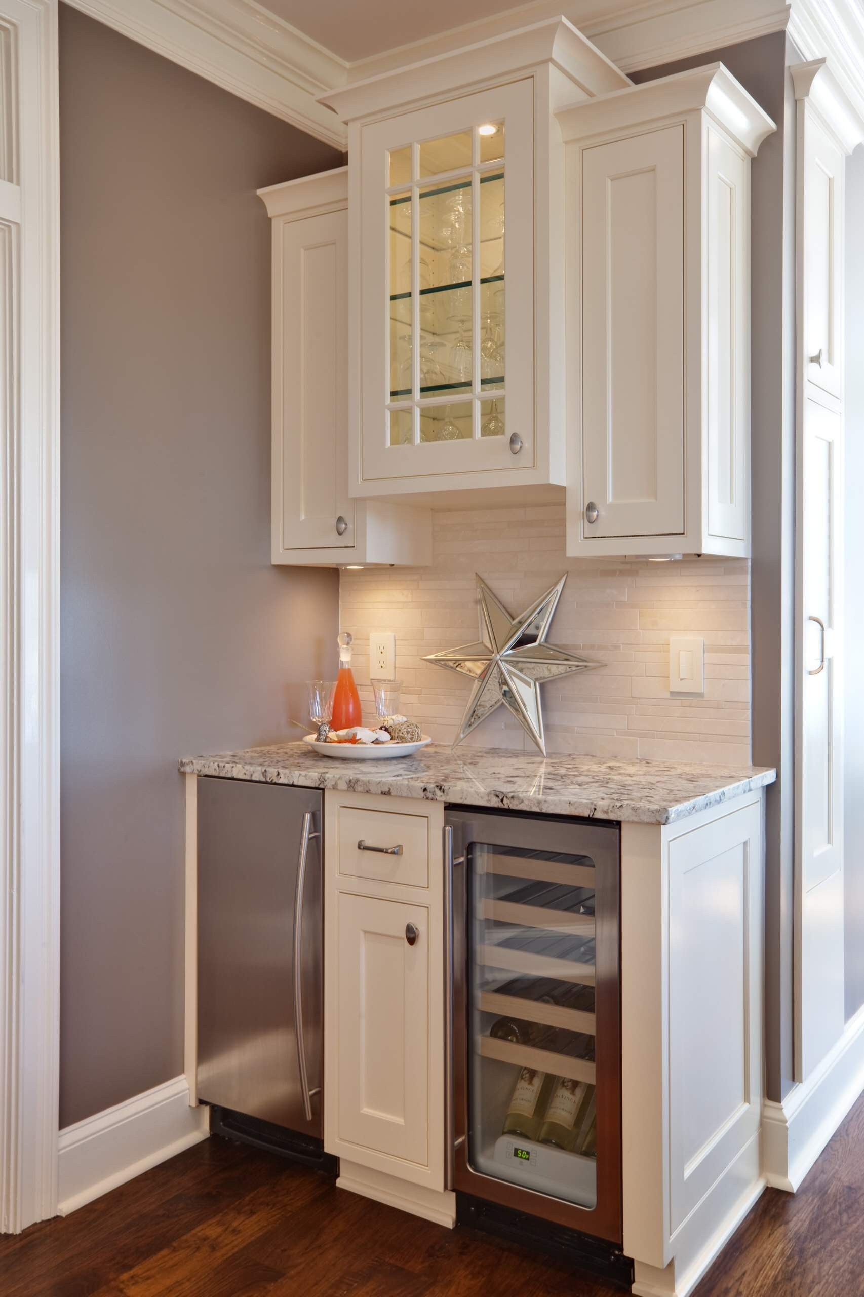White cabinet wetbar with a mini fridge and wine cooler