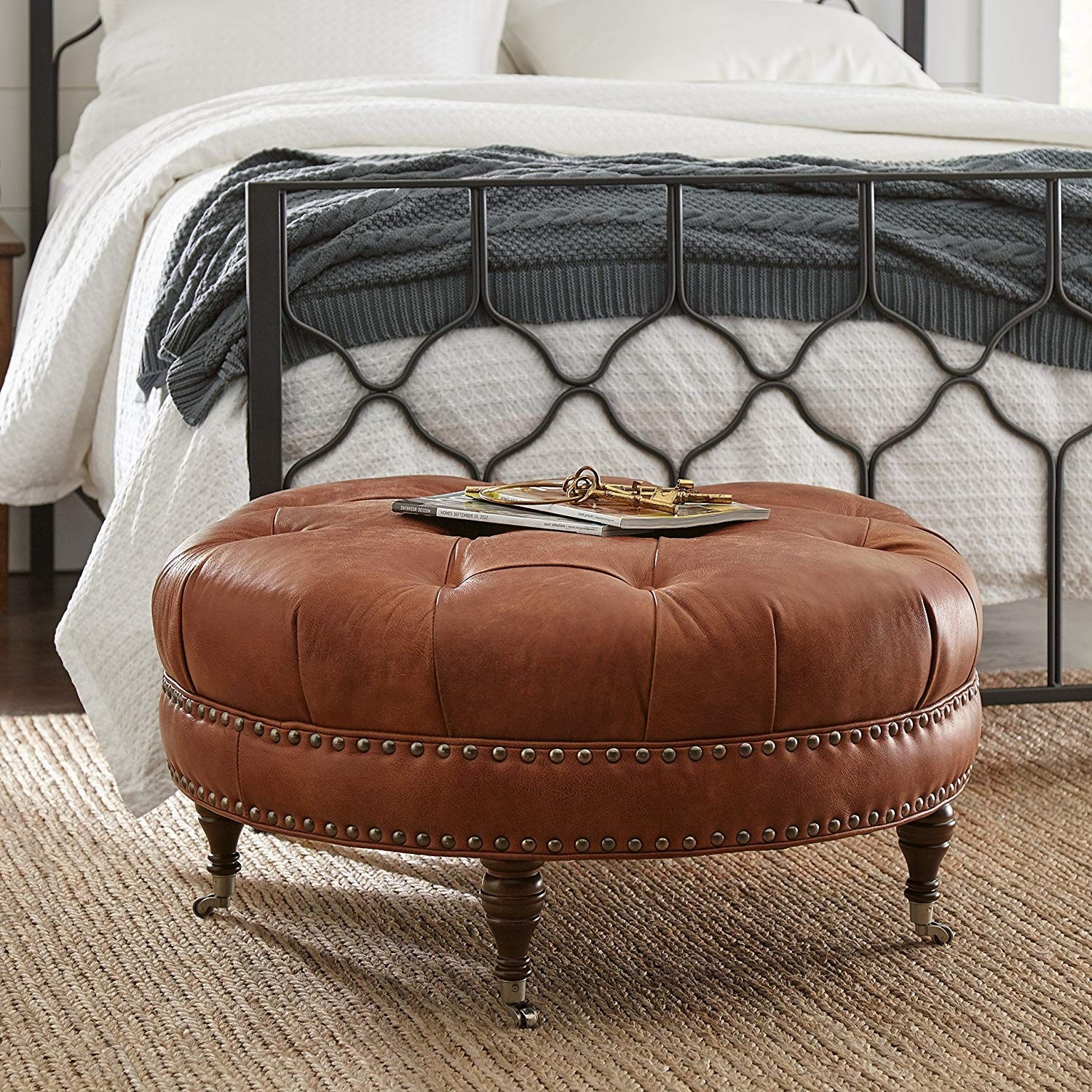 Button tufted round leather wheeled ottoman with spindled