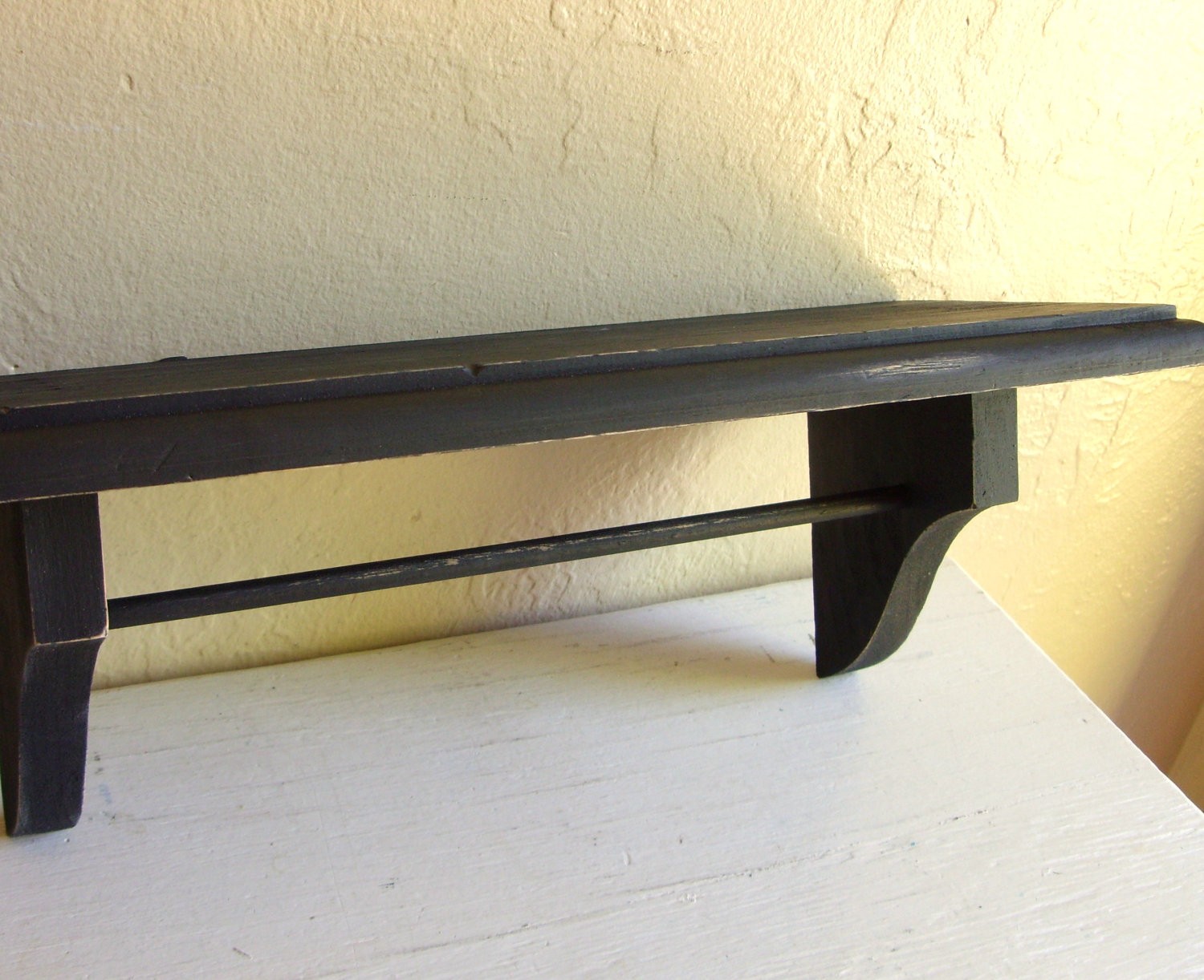 Distressed black wood wall shelf with hanging rod rustic