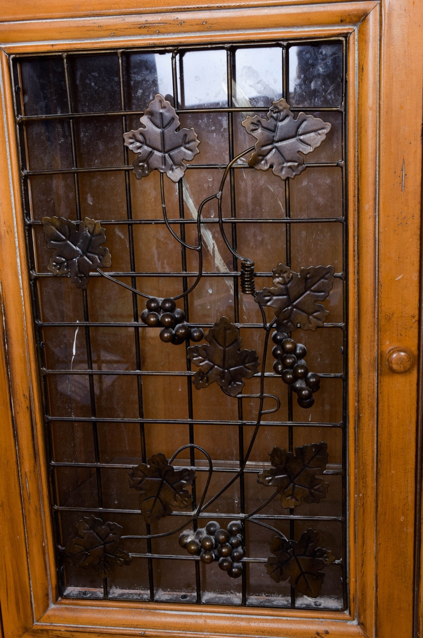 Ornate wine cabinet with glass and iron door panels ebth