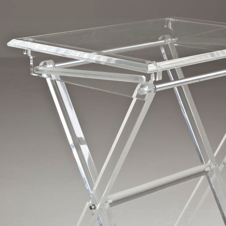 A pair of folding lucite tray tables with stand at