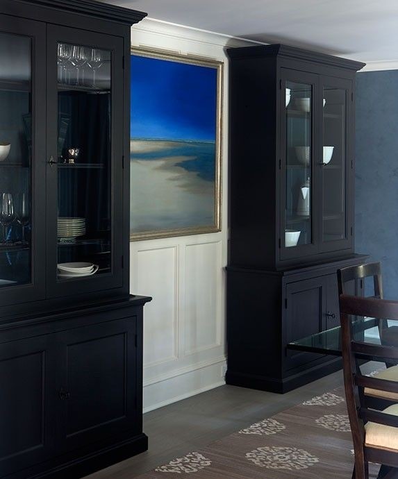 Chic dining room features tall black china cabinets