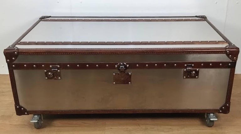 Stainless steel and leather bound trunk coffee table with 4