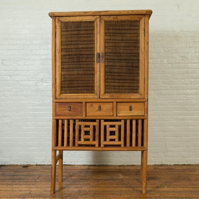 Indonesian cabinet with rattan doors drawers and fretwork 1