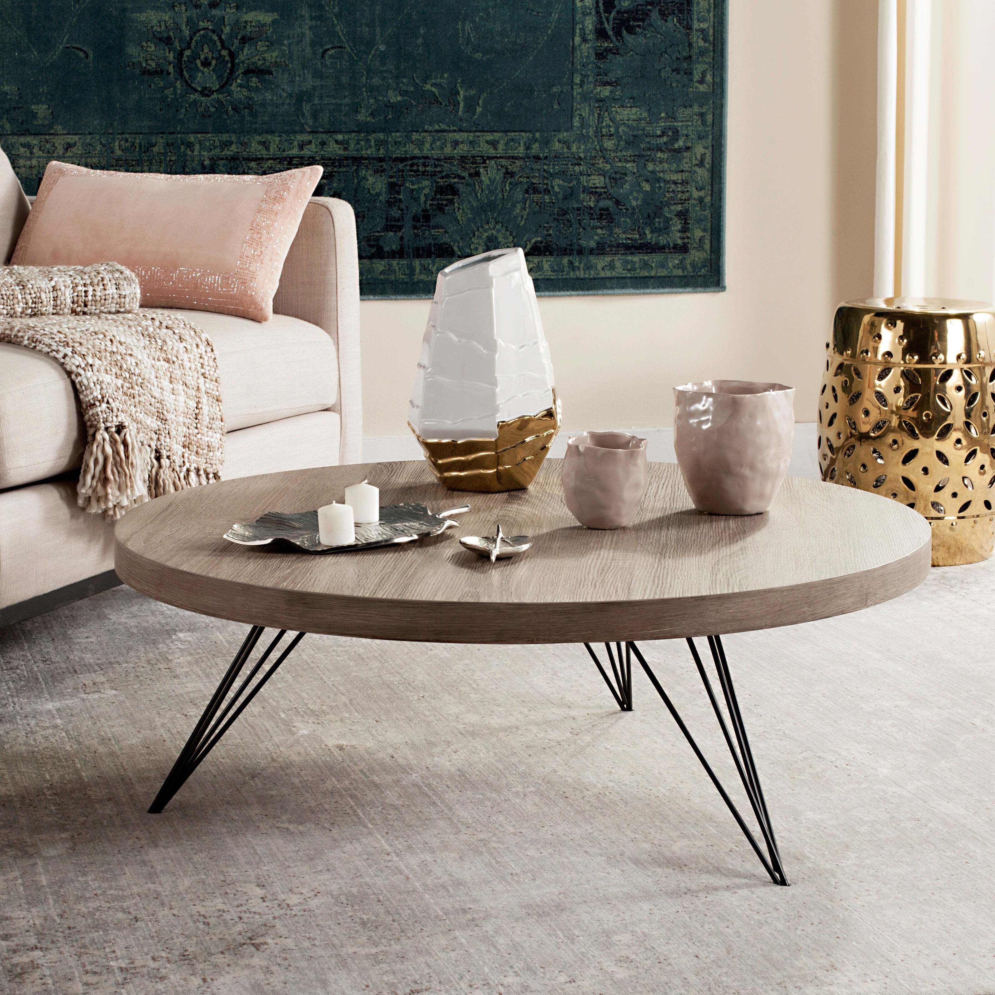 A circular coffee table with hairpin metal legs