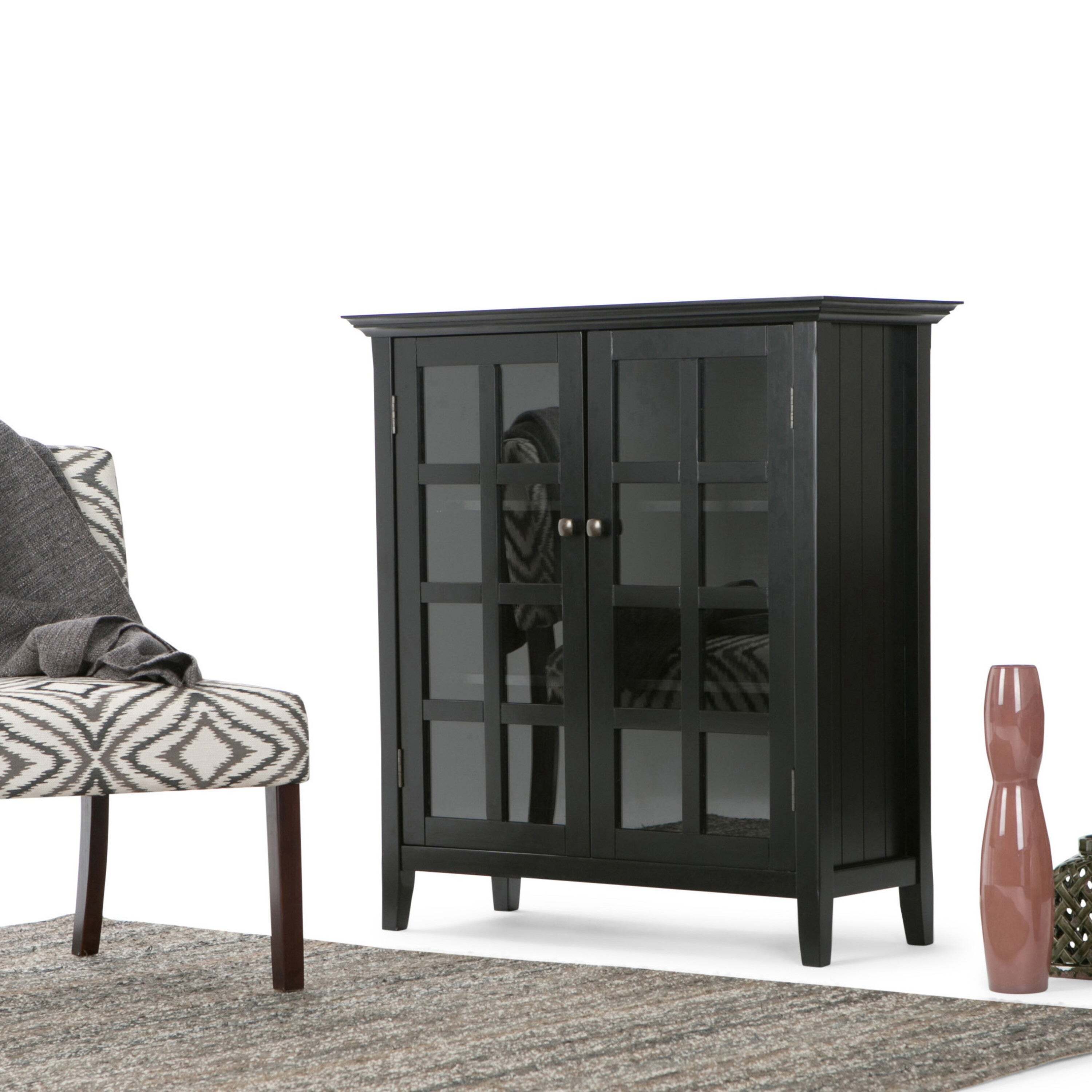 A stately dark wood cabinet with full size glass door inserts