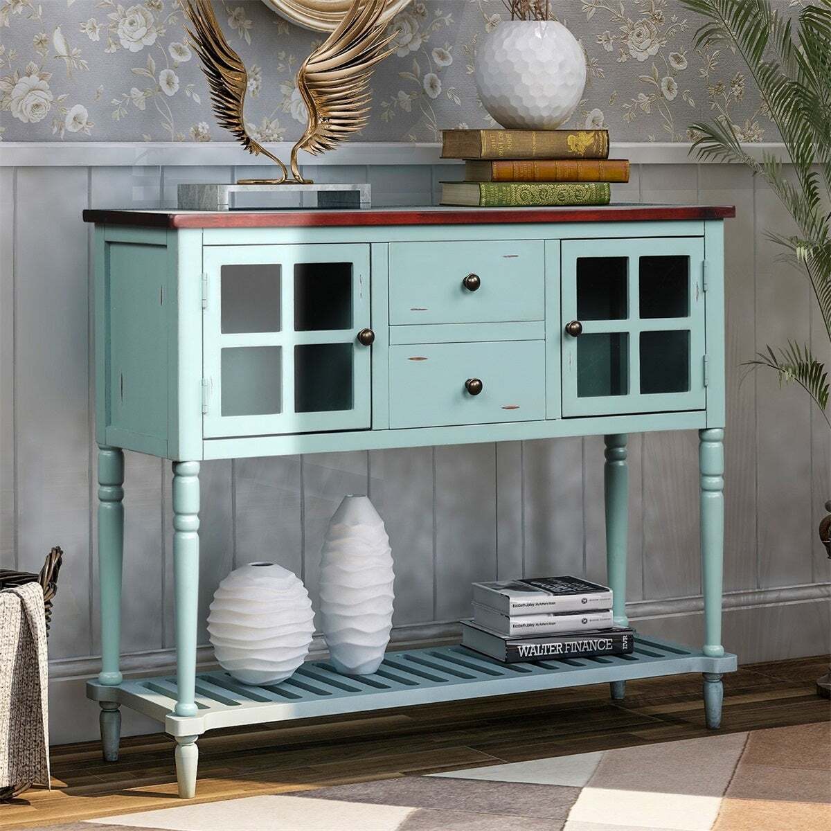 A teal small glass front cabinet on tall legs