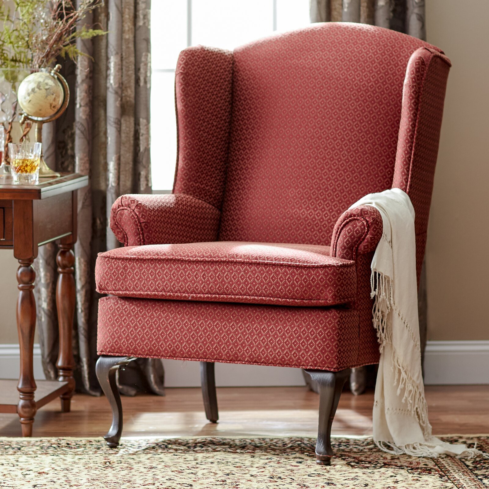 A traditional soft rose high wingback chair 