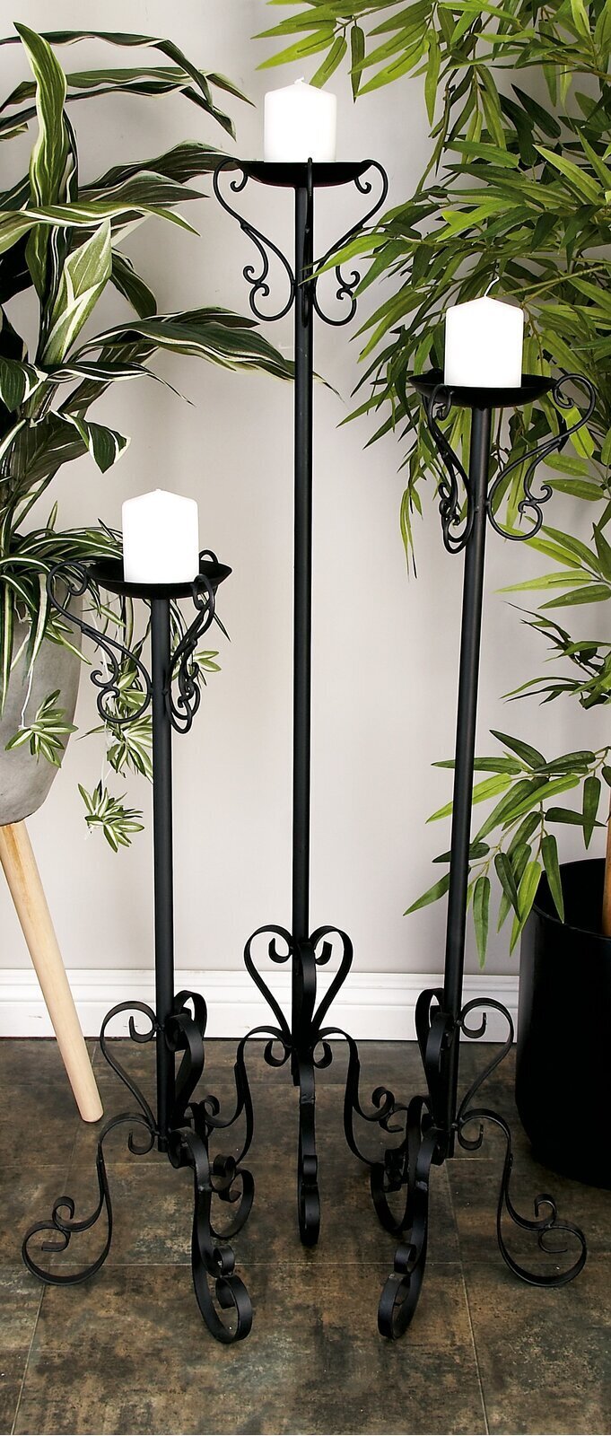 Wrought iron floor candle holders in a decreasing order