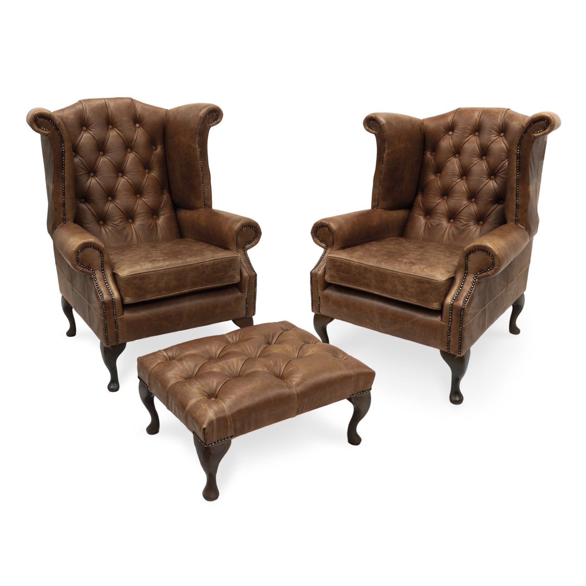 A Pair Of Chesterfield Queen Anne High Back Wing Chairs And Matching Footstool In Vintage Brown Leather